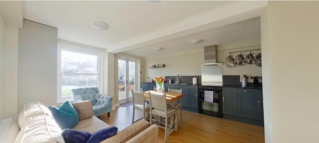 a kitchen and living room with a couch and a table at North Lodge in Cheltenham