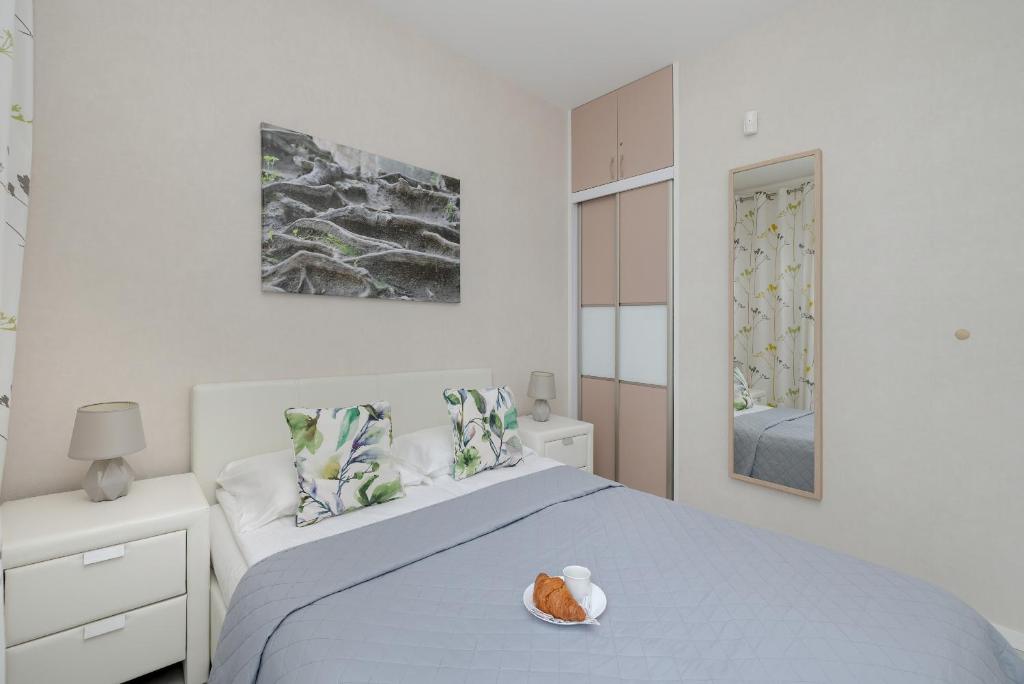 a white bedroom with a bed with a bowl of food on it at Apartment MiAMar in Rogowo with Furnished Terrace and Parking by Renters in Rogowo