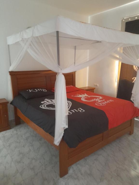 1 dormitorio con 1 cama con dosel en La doré du Sénégal, en Somone