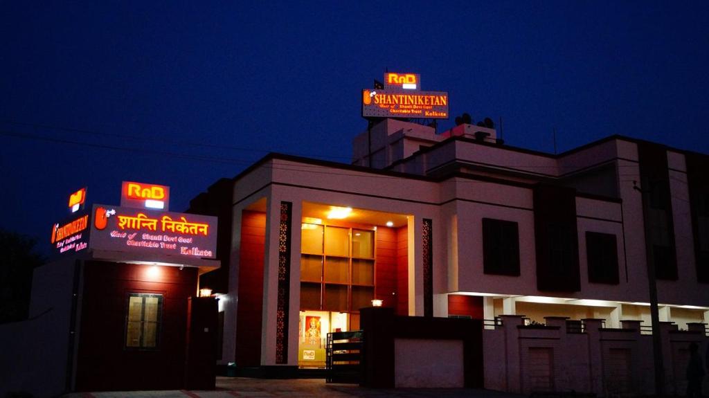 a building with neon signs on top of it at night at SALASAR Shanti Niketan in Sīkar