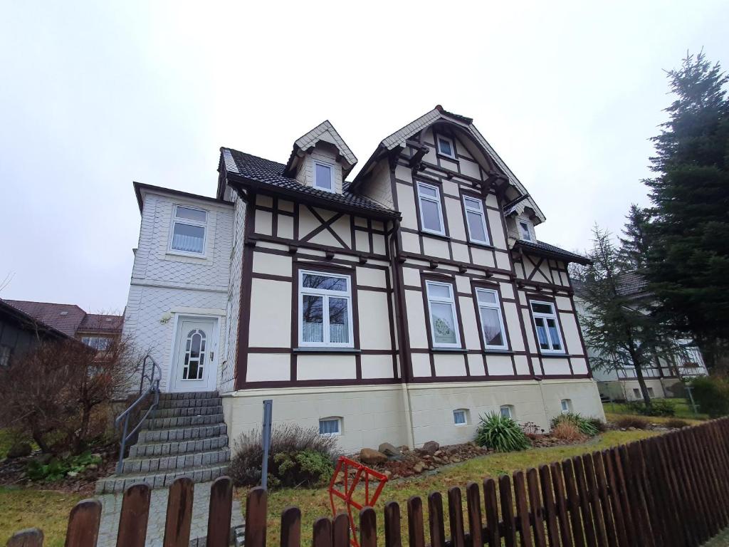 una casa con una valla de madera delante de ella en Ferienwohnung Wilde Bergwiese, en Benneckenstein