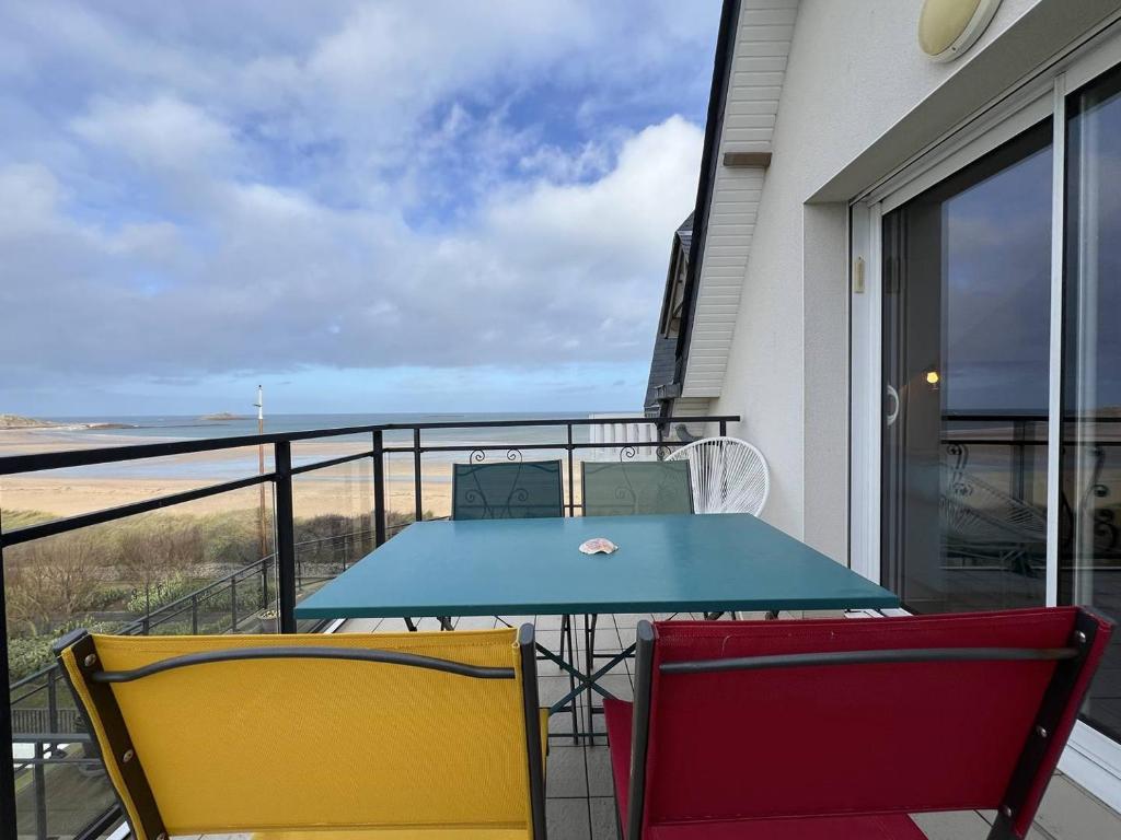 une table et deux chaises sur un balcon dans l'établissement 103 - Appartement vue mer pour 4 personnes, à Fréhel