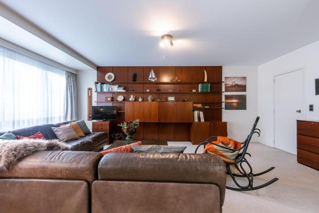 ein Wohnzimmer mit einem braunen Sofa und einem Tisch in der Unterkunft Apartment Alios in Ostende