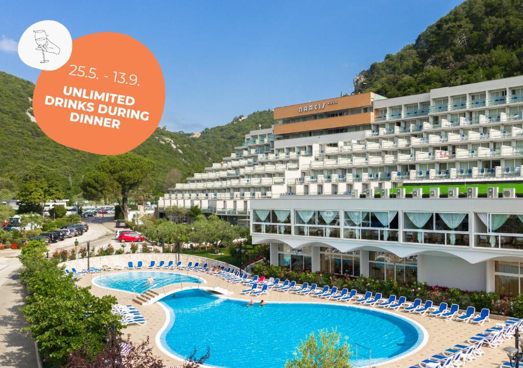 a hotel with a swimming pool and a building at Hotel Narcis - Maslinica Hotels & Resorts in Rabac