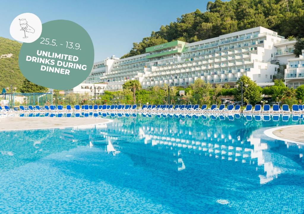 una gran piscina con un edificio en el fondo en Hotel Hedera - Maslinica Hotels & Resorts en Rabac