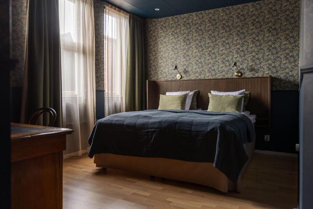 Gibsons Hotell في Jonsered: غرفة نوم مع سرير مع اللوح الأمامي الخشبي