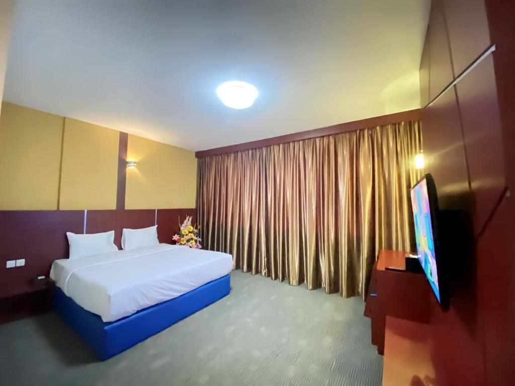 Giường trong phòng chung tại D'MERLION HOTEL