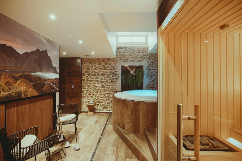 a home with a bar in the middle of a room at Auberge de Clochemerle, Spa privatif & restaurant gastronomique in Vaux-en-Beaujolais