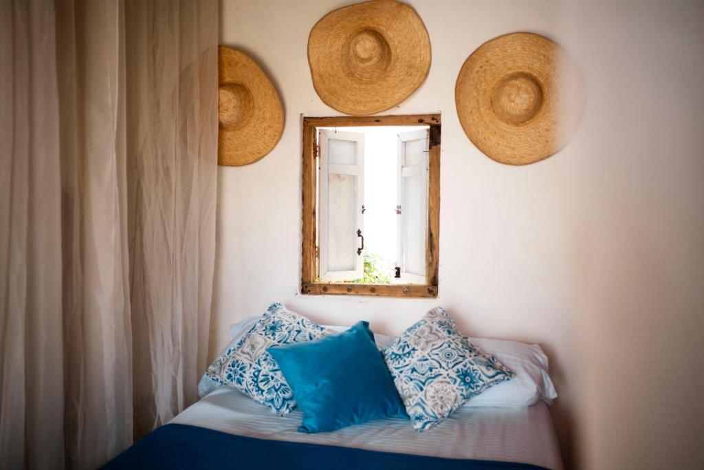 Un dormitorio con una cama con almohadas azules y una ventana en Cabaña Aguadulce, en San Rafael