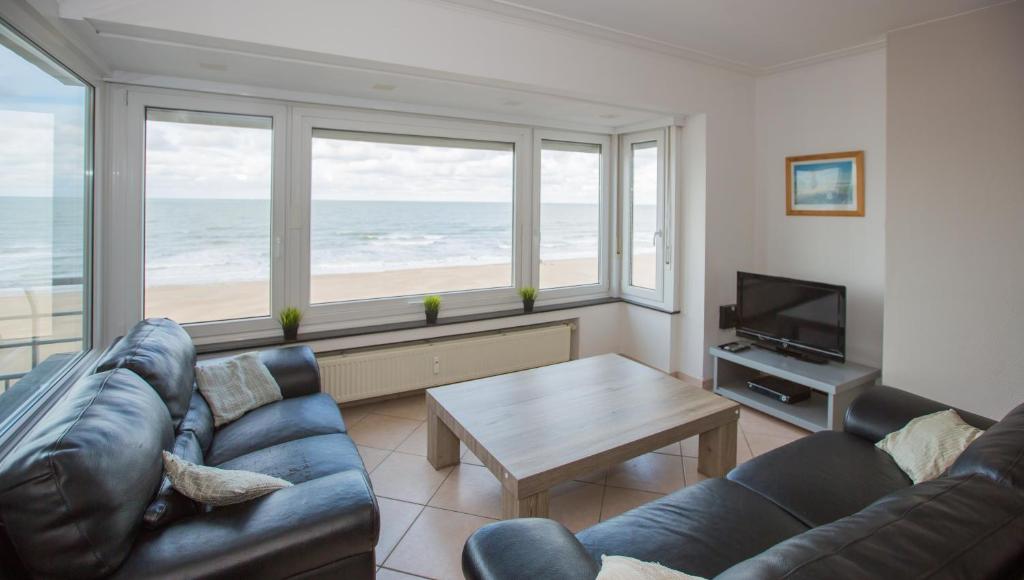 salon z kanapą i stołem w obiekcie Bright Apartment With Sea View w Ostendzie