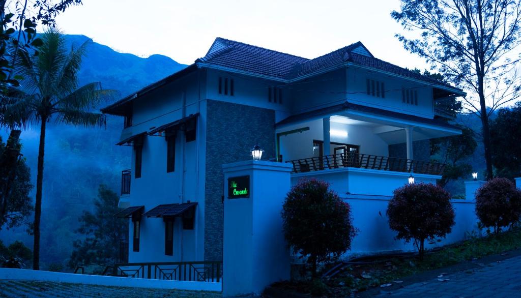 a blue house with a sign in front of it at The Cascade Munnar in Anachal