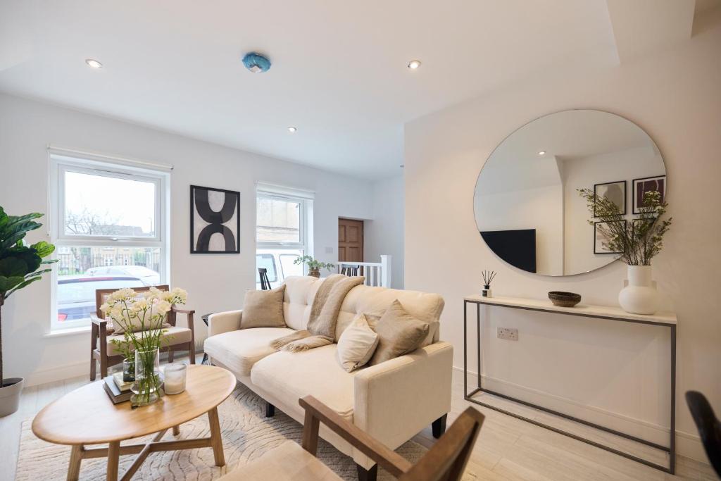 The Kingswood Place - Modern 2BDR with Terrace في West Dulwich: غرفة معيشة مع أريكة ومرآة