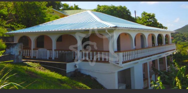 a large building with a blue roof on a hill at Immaculate 3 Bed Villa & Studio Apartment in Union