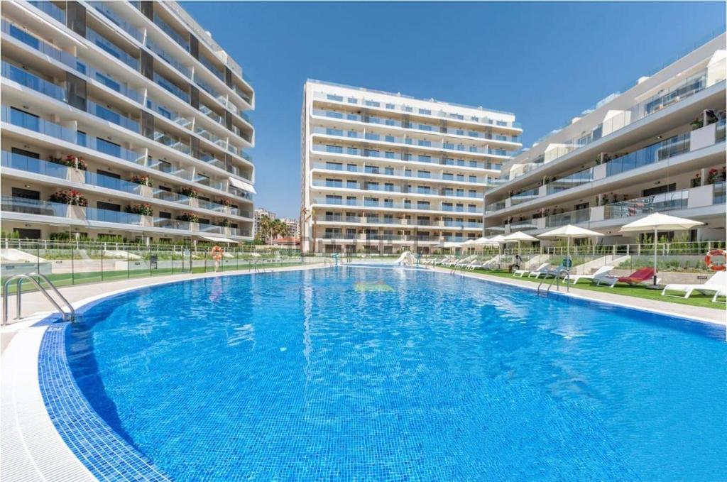 een groot zwembad voor twee appartementengebouwen bij The Style en Pau-5 playa San Juan de Alicante in Alicante