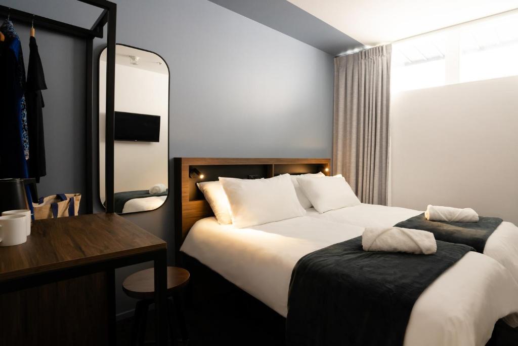 Una habitación de hotel con una cama grande y un escritorio. en Haka House Auckland City, en Auckland