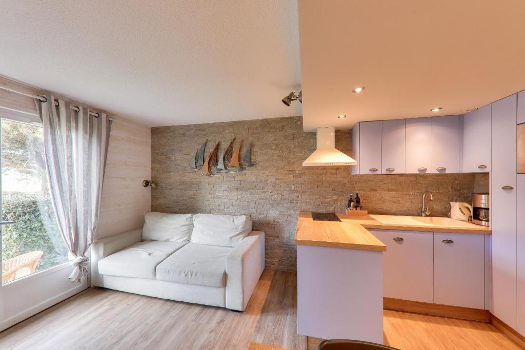 un salon avec un canapé blanc dans une cuisine dans l'établissement Séjour à Arzon à deux pas du Port du Crouesty, à Arzon