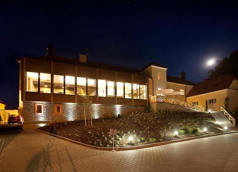 a large building with lights in front of it at night at Hotel Pod Zámkem in Boskovice