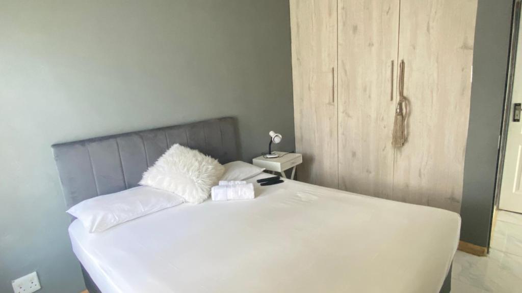 a white bed with white pillows on top of it at Ubuhle Guest House in Standerton