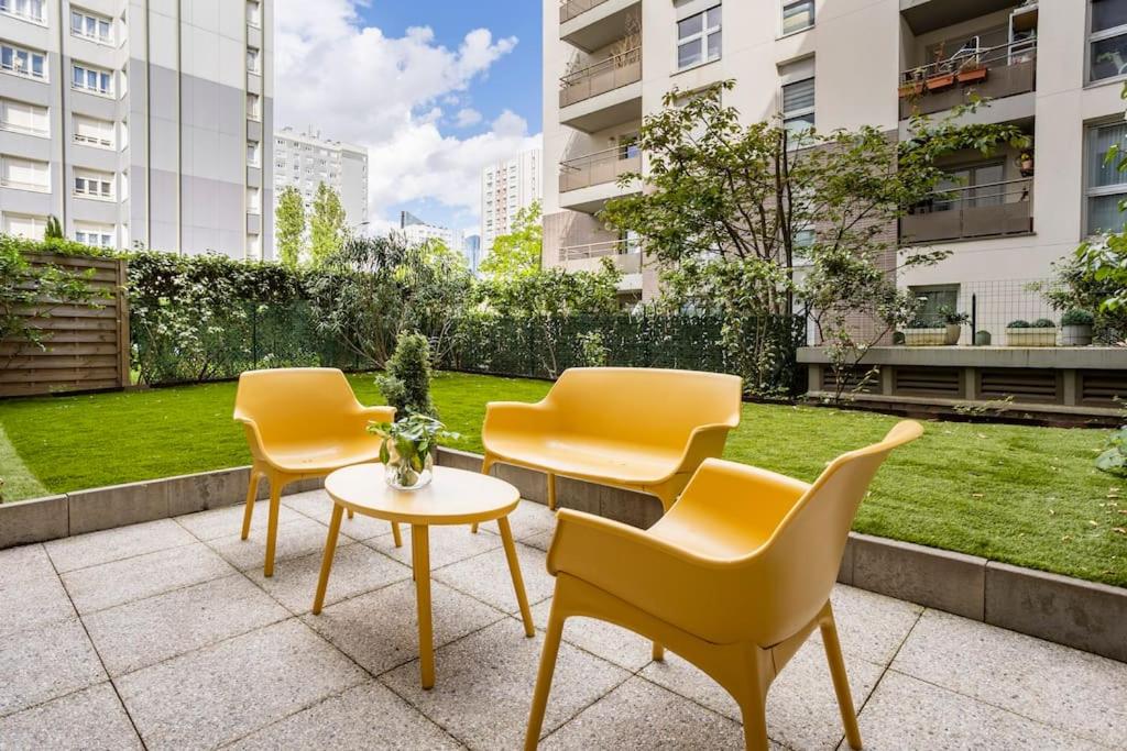 a patio with yellow chairs and a table and grass at Garden /20 min Champs Elysees /30 min Eiffel Tower in Nanterre