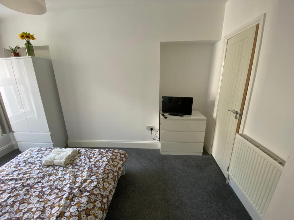 a small bedroom with a bed and a television at The Sunflower En-suite Room in Plymouth