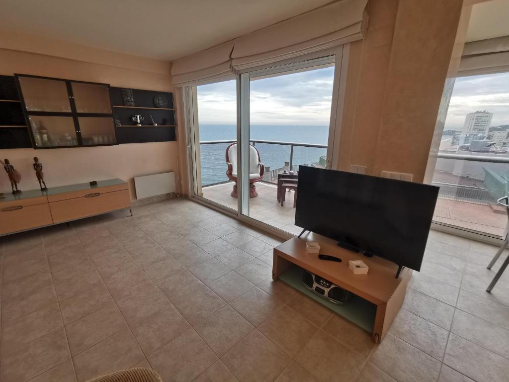 uma sala de estar com uma televisão de ecrã plano e uma janela grande em Apartamento Platja d'Aro, 3 dormitorios, 5 personas - ES-209-42 em Platja  d'Aro