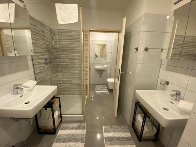 a bathroom with two sinks and a toilet at New Central Apartments Westbahnhof in Vienna