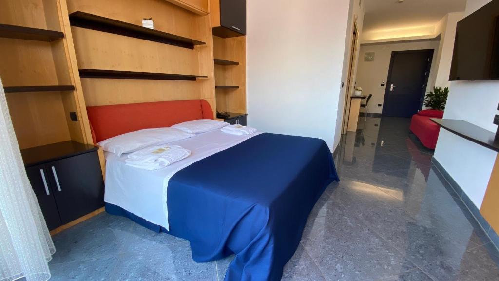 a small room with a bed with a blue blanket at Blu Residence - Hotel nel Salento in Casarano