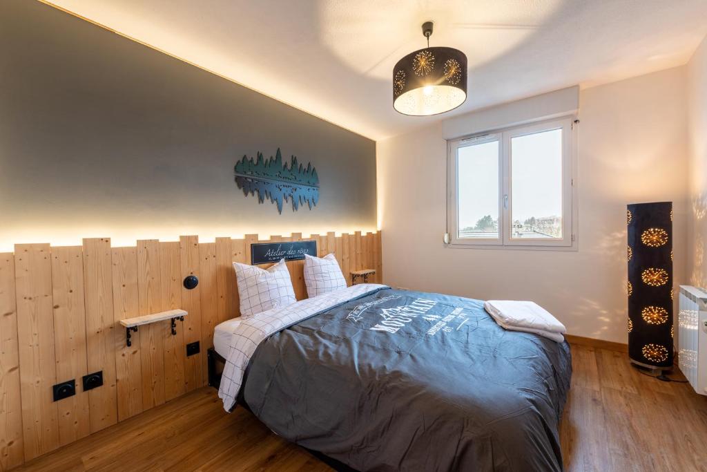 a bedroom with a large bed and a window at Les Cèdres Bleus in Albertville