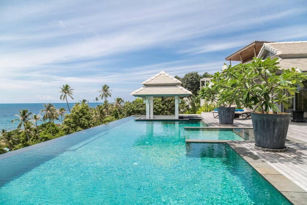 a swimming pool with a gazebo next to the ocean at Luxury villa Seaview & Sunset 100m from the beach in Ko Phangan