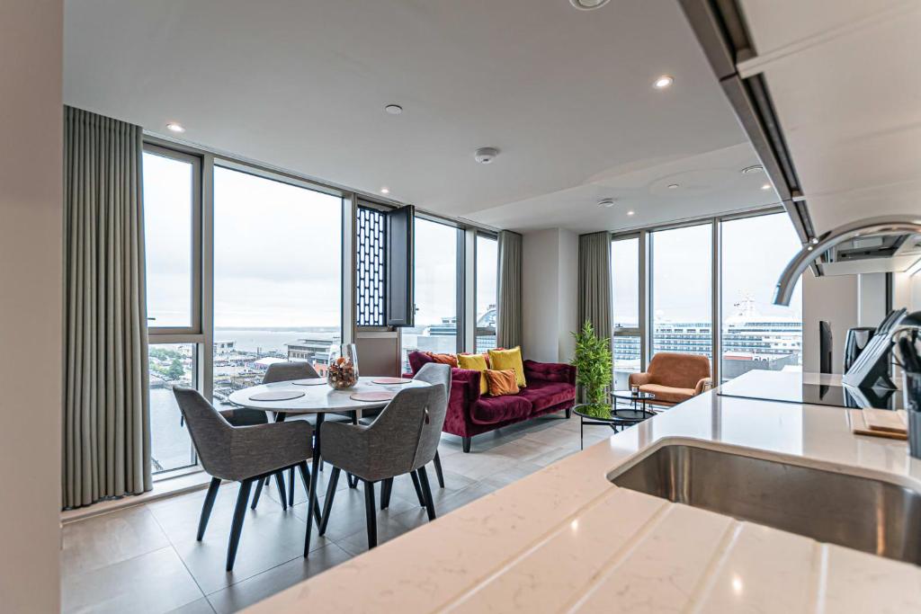 a kitchen and living room with a table and chairs at The Lexington - Luxury Serviced Apartments City Centre - City and Waterfront views in Liverpool
