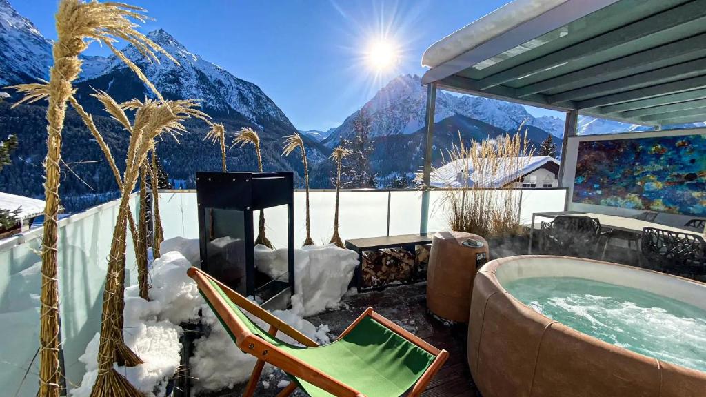 a hot tub with a view of a mountain at Ferienwohnung Chasa Splerin mit Whirlpool auf Terrasse in Scuol