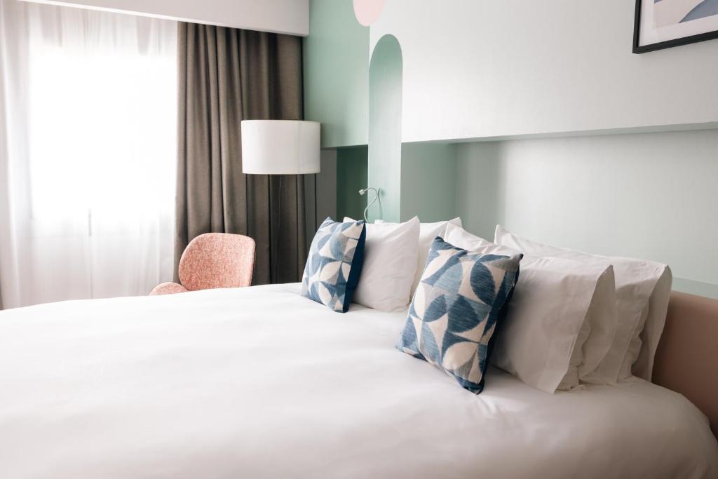 A bed or beds in a room at voco Madrid Retiro by IHG