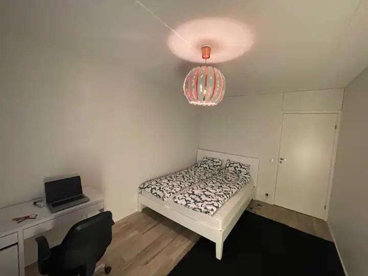 a bedroom with a bed and a desk and a chandelier at comfort room in Helsinki