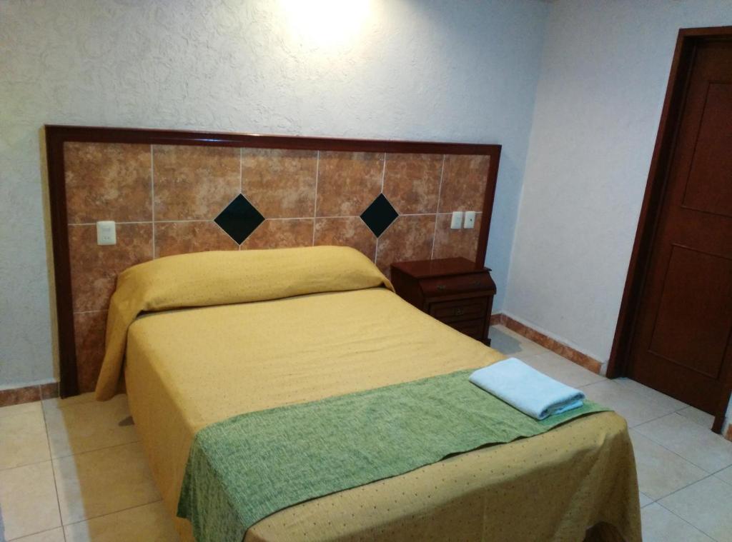 坎佩切的住宿－Hotel Nicte-Ha，一间卧室配有一张黄色床罩的床