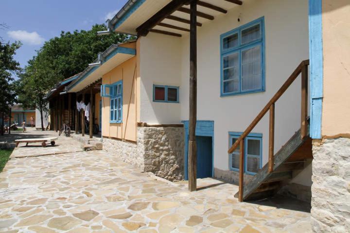 een gebouw met blauwe ramen en een trap ernaast bij Villa Panorama in Pomoshtitsa