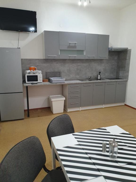 La cuisine est équipée d'une table, de chaises et d'un réfrigérateur blanc. dans l'établissement Ubytovna Moravan Brno, à Brno