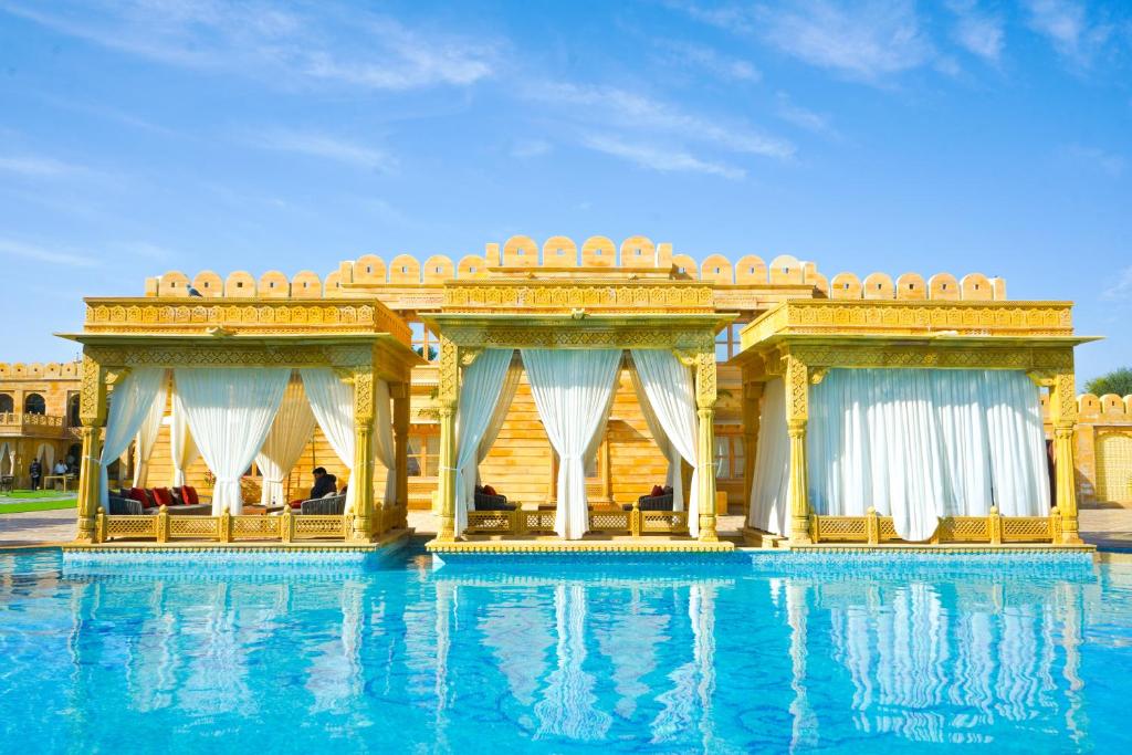 a large swimming pool in front of a building at Fort Rajwada,Jaisalmer in Jaisalmer