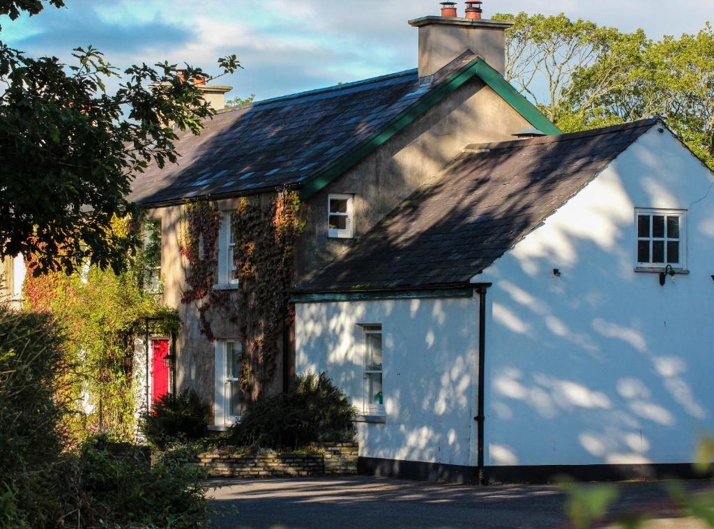 una vieja casa blanca con una puerta roja en Ballylagan Organic Farm, en Straid