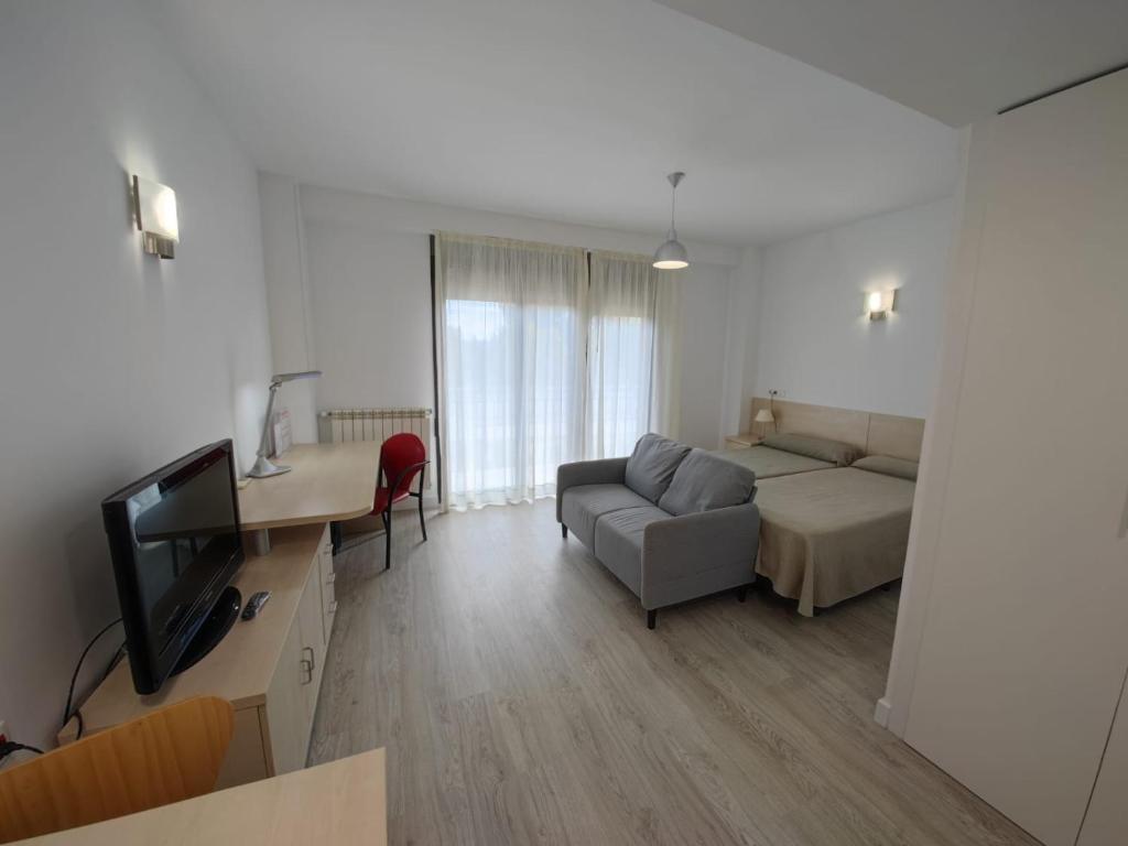 a living room with a couch and a television at Residencia Universitaria Giner de Los Ríos in Alcalá de Henares