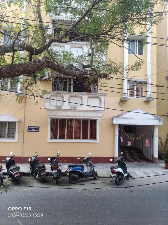 una fila de scooters estacionados frente a un edificio en 25 guest house, en Pondicherry