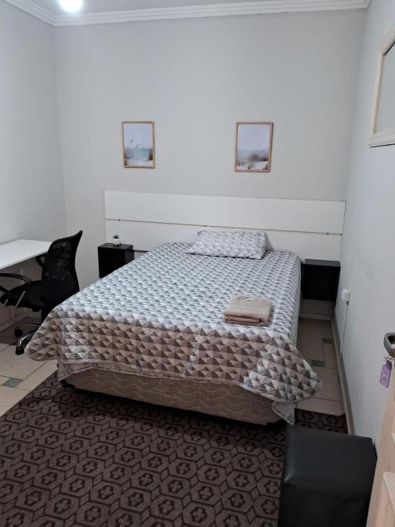 - une chambre avec un lit et un bureau dans l'établissement Dormitório 2 aconchegante a 2km de Alphaville, à Barueri