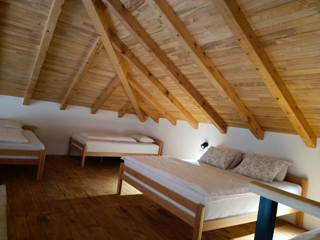 a bedroom with two beds and wooden ceilings at Vikendica Krcmarice- Banja Luka in Banja Luka
