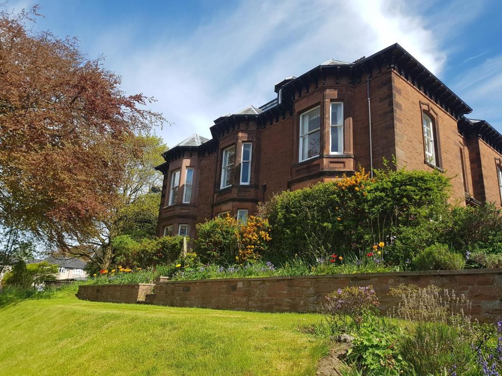 a large brick house with a garden in front of it at 3 Forest House in Penrith