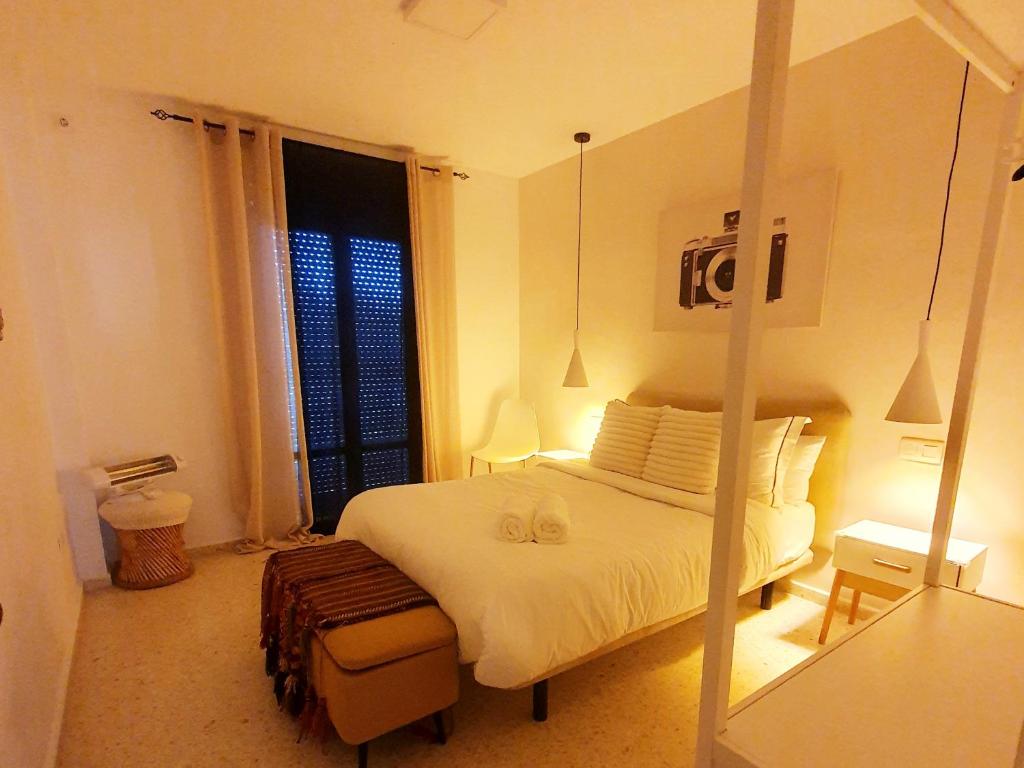 - une chambre avec un lit blanc et un miroir dans l'établissement Apartamento Rural El Bandolero, à El Bosque