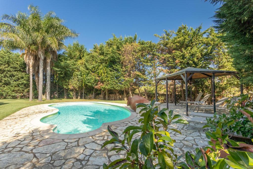 a swimming pool with a gazebo and trees at Villa Cecilia in Cinisi