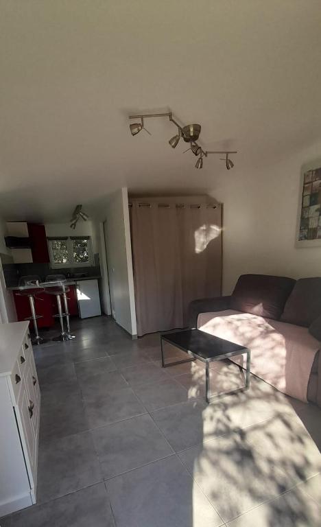 un salon avec un canapé et une table dans l'établissement Studio climatisé indépendant de 24m², à Calvi