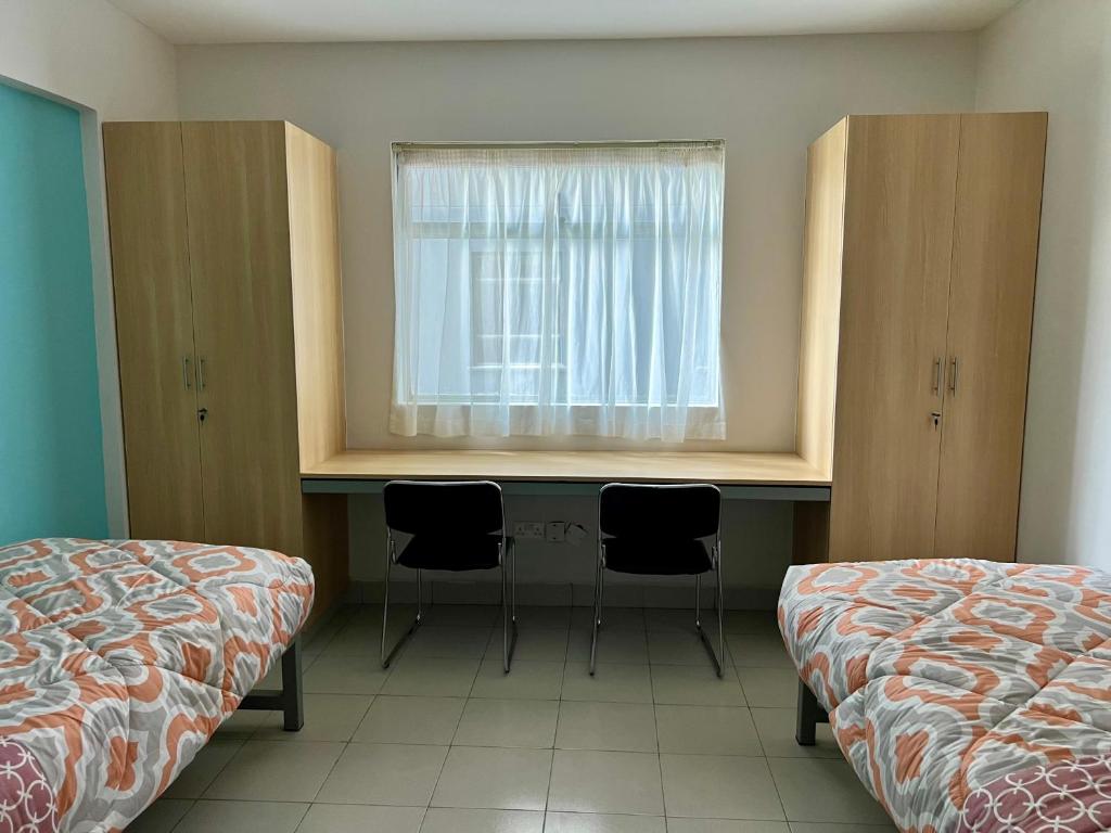 een slaapkamer met een bureau en een raam met 2 stoelen bij ADANA PODS in Nairobi