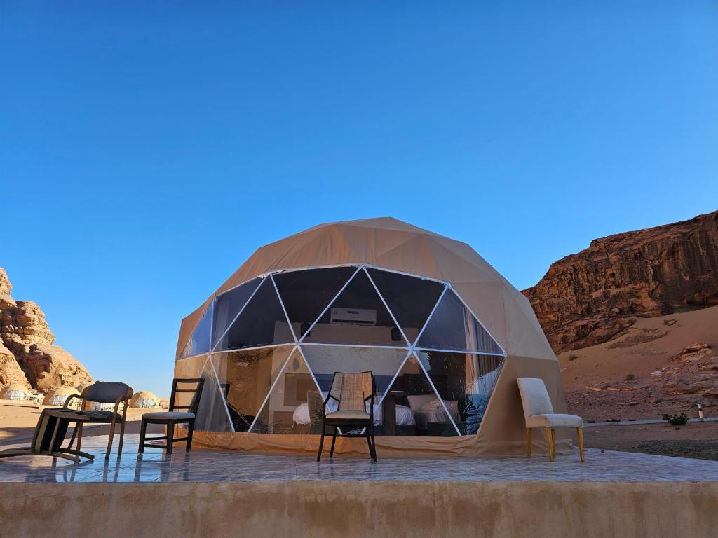 une tente en forme de dôme avec des chaises dans le désert dans l'établissement Sama Rum Camp, à Wadi Rum