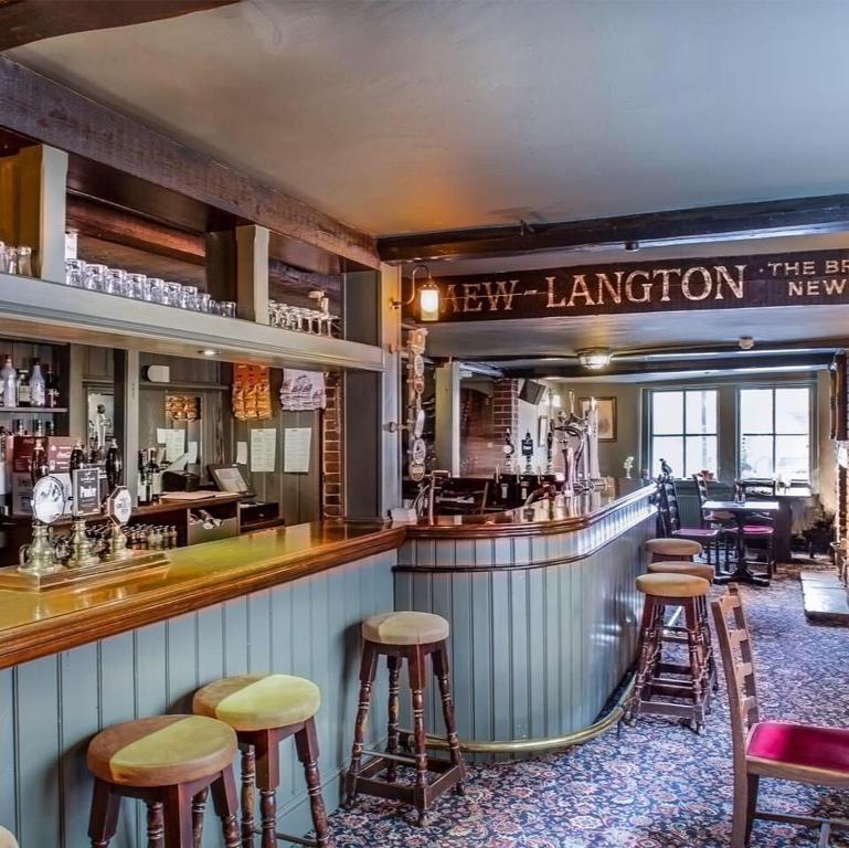 a bar at a restaurant with stools at Wheatsheaf Hotel in Newport