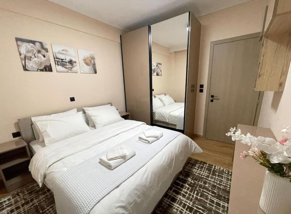 ein Schlafzimmer mit einem großen weißen Bett und einem Spiegel in der Unterkunft The MODERN apartment in Thessaloniki